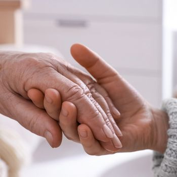 young and elderly women holding hands